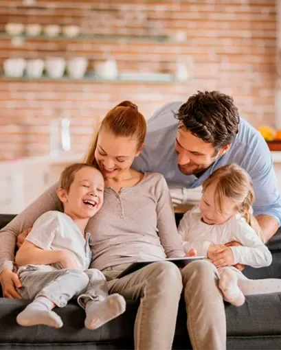 Familia sentada en sofá sonriendo